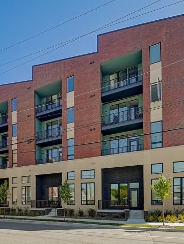 a red brick apartment building with green balconies