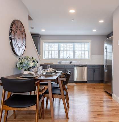 A modern kitchen with a dining table set for two.