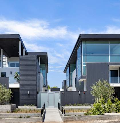 a row of modern houses with black facade and glass windows