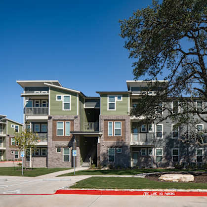 Apartment complex with a tree in front.