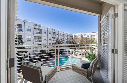 a balcony with two chairs and a view of a pool