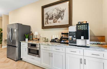a kitchen with white cabinets and stainless steel appliances and a framed picture of a buffalo