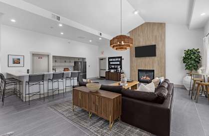 A modern living room with a fireplace and a brown couch.