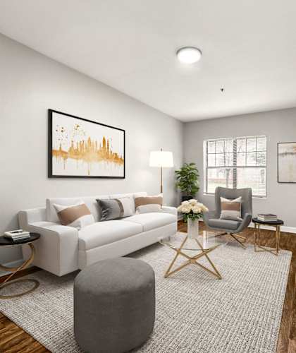 A modern living room with a white sofa, a grey ottoman, a wooden coffee table, and a large painting on the wall. at Crogman School Lofts in Atlanta, Georgia