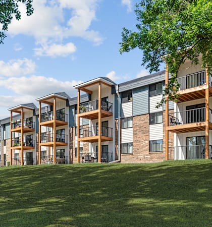 Apartment complex with green grass in front.