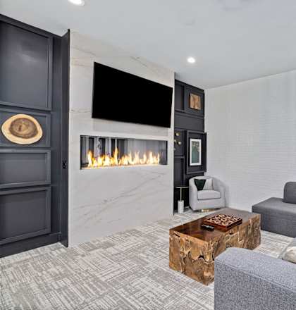 a living room with a gray couch and a fireplace