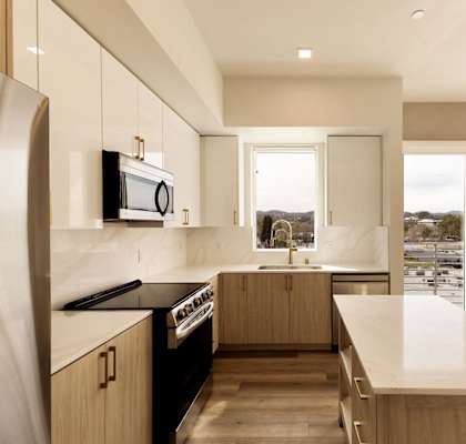 A modern kitchen with a large island and a view of the city.