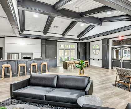 a living room with a couch and chairs and a kitchen at River Stone Ranch, Austin
