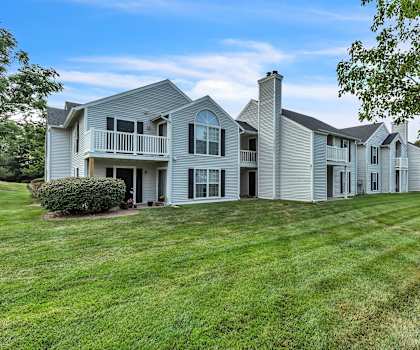 A large, modern house with a well-manicured lawn.