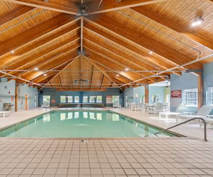 A large indoor swimming pool with a wooden ceiling.