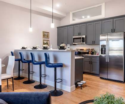 A kitchen with a bar area and chairs.