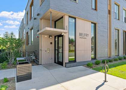the belby apartments exterior entrance with sidewalk and grass