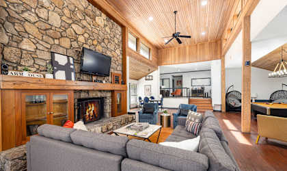 the living room has a large stone fireplace and a large couch