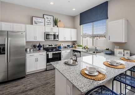 A modern kitchen with granite countertops and stainless steel appliances.