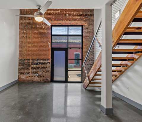 A room with a brick wall and a ceiling fan.