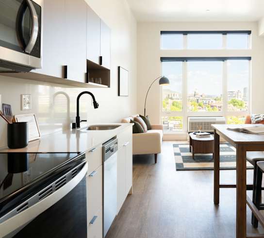 A modern kitchen with a dining table and chairs.