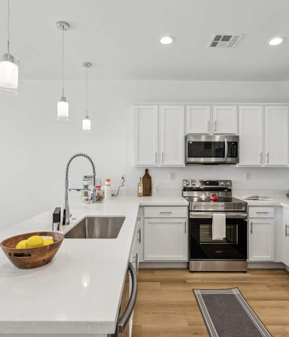 a kitchen and dining room with white cabinets and a white counter top