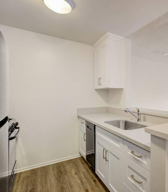 A kitchen with white cabinets and a white countertop. at Mariposa Gardens, Los Angeles, CA