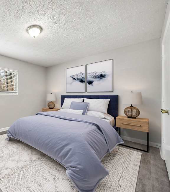 A bedroom with a bed, chair, and pictures on the wall at Balfour Forest Apartments in Marietta, Georgia, 30008