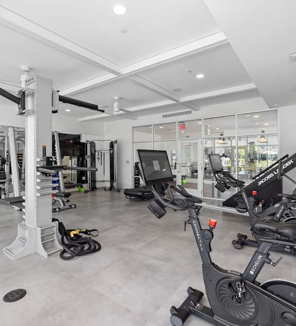 A gym with a variety of equipment including treadmills, weights, and exercise machines.
