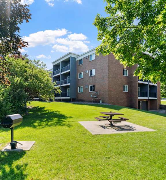 our apartments have a large swimming pool with chairs  at Cedars Lakeside, Minnesota