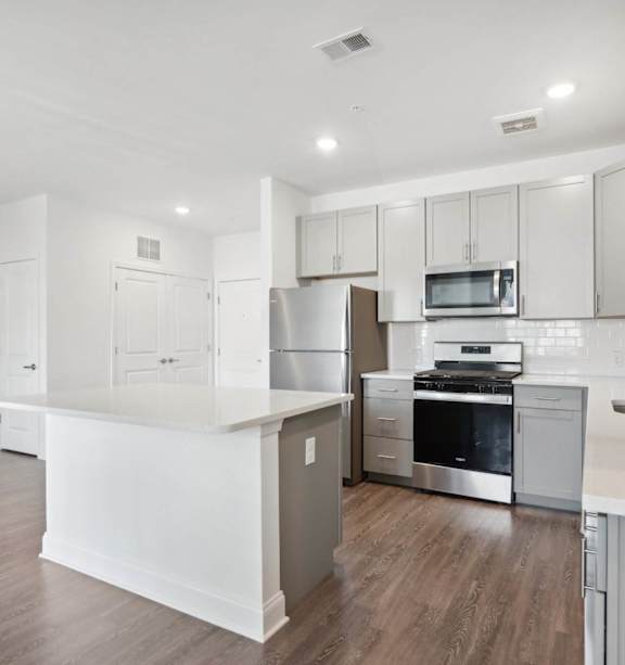 A modern kitchen with stainless steel appliances and white cabinetry.
