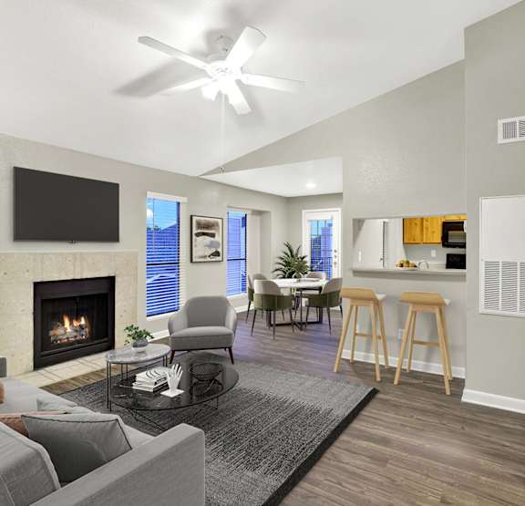 a living room with a ceiling fan and a dining room table with chairs at Seacrest Apartments, Garland, 75044