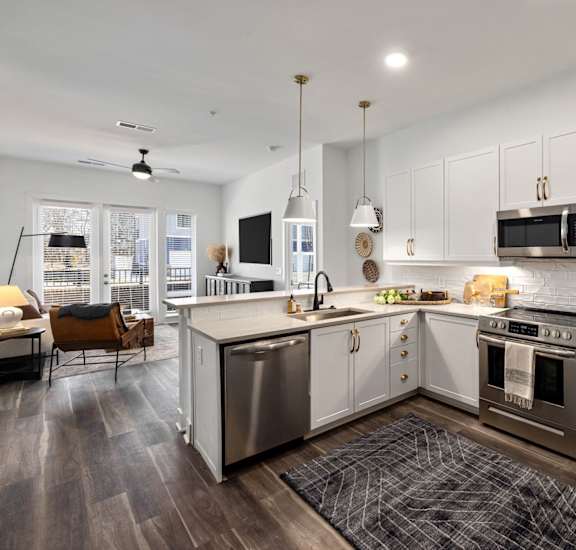 A modern kitchen with white cabinets and stainless steel appliances.