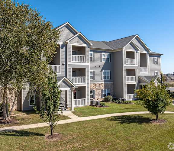 A large apartment building with a tree in front of it.