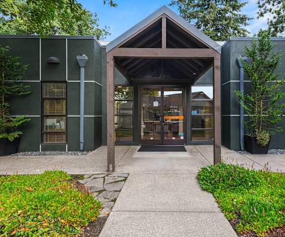 A building with a wooden entrance and a stone pathway leading to it.