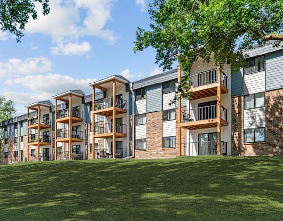Apartment complex with green grass in front.