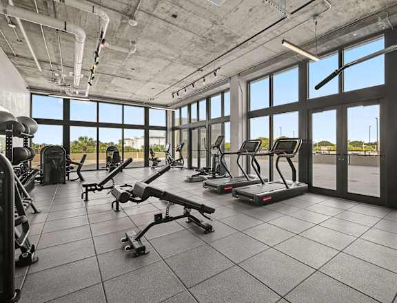 A gym with treadmills, elliptical machines, and other exercise equipment.