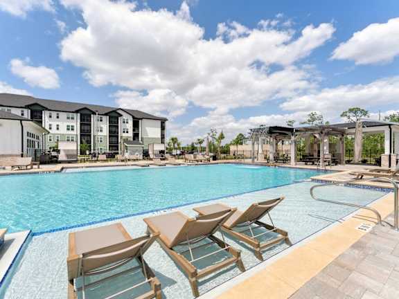 A large apartment complex with a parking lot in front at The Hendry Apartments, Fort Myers, FL, 33905
