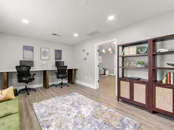 A room with a green couch, a rug, and a bookshelf at 445 Cleveland Apartments in Georgia, 30354