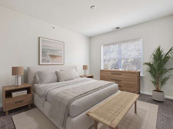 A bedroom with a bed, nightstand, and a plant.