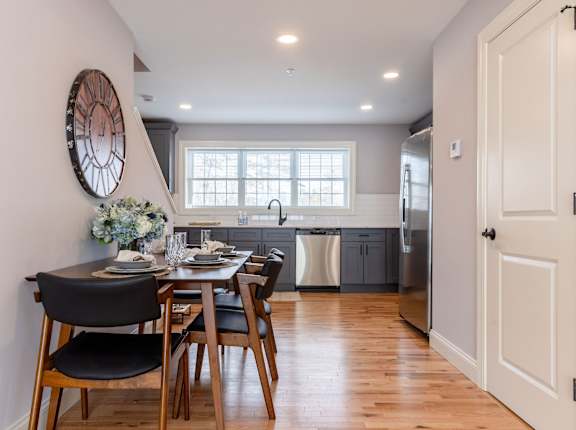 A modern kitchen with a dining table set for two.