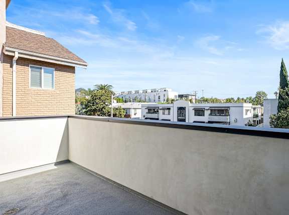 the view from the roof terrace of a house with a balcony and a building