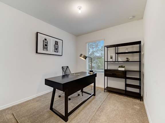 a home office with a desk and a bookshelf
