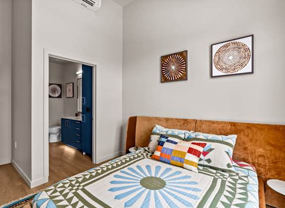 A bedroom with a bed and two pictures on the wall.