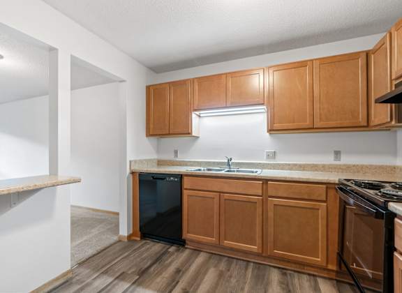 an empty kitchen with wooden cabinets and a stove and sink