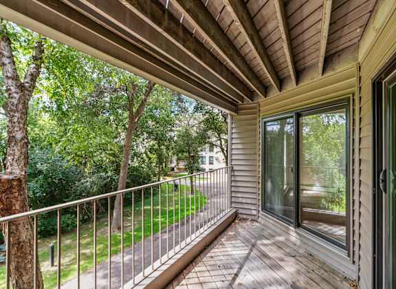 the screened in porch has a view of the yard and trees