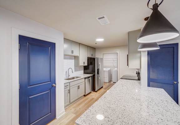 a renovated kitchen with blue doors and white cabinets