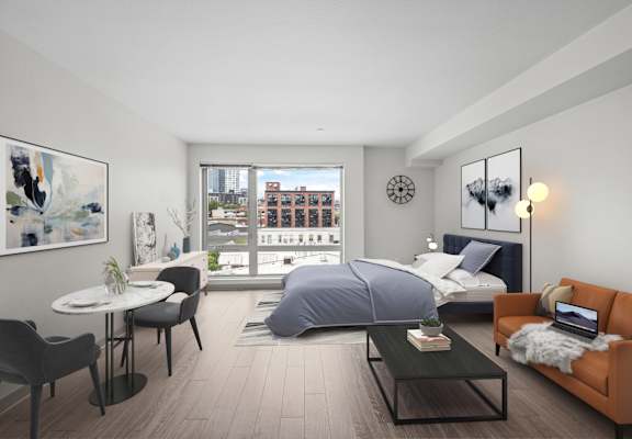 A modern bedroom with a large bed, a desk with a laptop, and a view of the city.