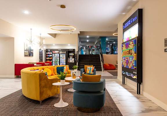 the lobby of a hotel with couches and chairs and a vending machine