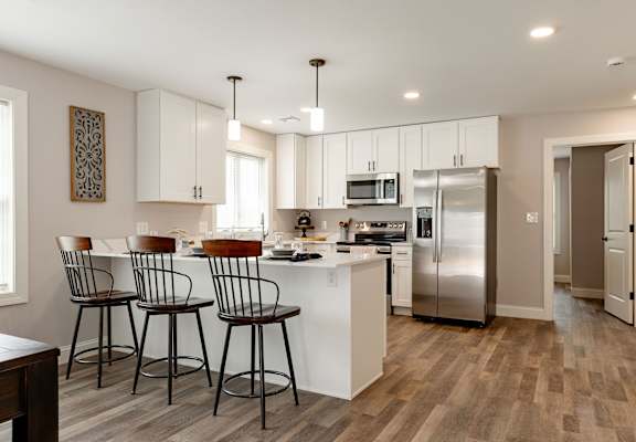 A kitchen with white cabinets and a refrigerator.