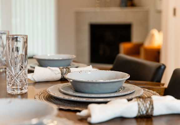 A table set for a meal with a glass, napkin, and a plate.