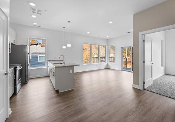 A spacious kitchen with a refrigerator, sink, and cabinets.