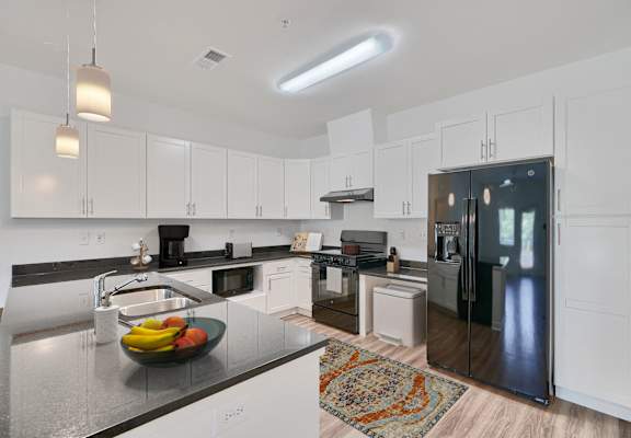 a large kitchen with white cabinets and stainless steel appliances