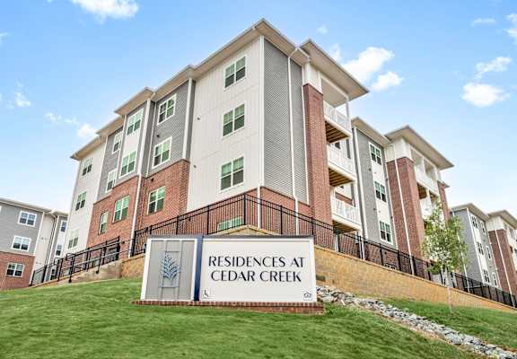 the residences at cedar creek apartments sign in front of building