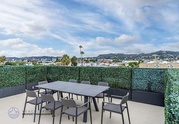 A table with chairs on a patio with a view of the city.